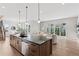 Open-concept living space with a large kitchen island, dining area, and living room featuring sliding glass doors at 1426 Swan Peter Dr, Berthoud, CO 80513