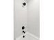 Modern shower with white tiled walls, a dark shower head, and dark fixtures highlighting a clean and sleek design at 1426 Swan Peter Dr, Berthoud, CO 80513