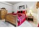 Cozy basement bedroom with wooden furniture and red bedding at 24237 E Glasgow Cir, Aurora, CO 80016