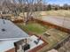 Aerial view of backyard, fenced perimeter, concrete patio and adjacent baseball field at 9395 W Kentucky Ave, Lakewood, CO 80226
