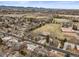 Aerial view showcasing neighborhood homes near large green park areas, ponds, tennis courts, and community amenities at 9395 W Kentucky Ave, Lakewood, CO 80226