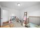 Cozy bedroom with a crib, natural light, and shelves with toys at 9395 W Kentucky Ave, Lakewood, CO 80226
