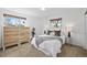 Bright bedroom with stylish dresser, soft carpet, and a comfortable queen-size bed with throw blanket at 9395 W Kentucky Ave, Lakewood, CO 80226