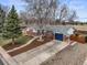 Charming single-story home featuring a blue garage door, brick accents, landscaped yard, and a spacious driveway at 9395 W Kentucky Ave, Lakewood, CO 80226