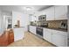Well-lit kitchen with white cabinets, stainless steel appliances, and tiled backsplash at 9395 W Kentucky Ave, Lakewood, CO 80226