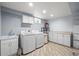 Well-lit laundry room featuring tile floors, washer, dryer and sink at 9395 W Kentucky Ave, Lakewood, CO 80226