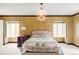 Cozy bedroom featuring decorative walls, two bright windows, an elegant chandelier, and a large bed at 2209 Green Oaks Ln, Greenwood Village, CO 80121