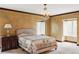 Spacious bedroom with a large bed, decorative chandelier, bedside table, and windows at 2209 Green Oaks Ln, Greenwood Village, CO 80121