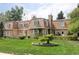 Expansive brick home with a lush green lawn and mature trees at 2209 Green Oaks Ln, Greenwood Village, CO 80121