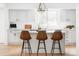 Stylish kitchen island with seating, complemented by elegant white cabinetry at 2209 Green Oaks Ln, Greenwood Village, CO 80121