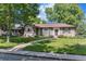 Charming single-story brick home with lush green lawn, mature trees, and inviting walkway at 801 S Steele St, Denver, CO 80209