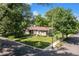 Charming single-story brick home with lush green lawn and mature trees on a corner lot at 801 S Steele St, Denver, CO 80209