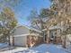 Two-story house with gray siding, brick accents, and a two-car garage; winter scene at 2676 S Troy Ct, Aurora, CO 80014