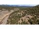 Panoramic aerial view of the property, highlighting the home's secluded location surrounded by lush trees and mountain views at 27341 Ridge Trl, Conifer, CO 80433