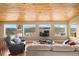 Inviting living room featuring mountain views from oversized windows and wood plank ceiling at 27341 Ridge Trl, Conifer, CO 80433