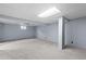 Unfinished basement featuring gray carpet, light blue walls, drop ceiling, and exposed support beam at 3720 S Fairplay Way, Aurora, CO 80014