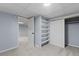 Basement featuring neutral carpet, blue walls, open closet with shelving, and door to additional room at 3720 S Fairplay Way, Aurora, CO 80014