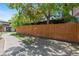 A home's exterior featuring a wood fence, green trees, and a sidewalk on a sunny day at 3720 S Fairplay Way, Aurora, CO 80014