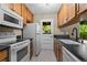 Efficient kitchen featuring wooden cabinets, white appliances, and a window-door leading to the outside at 3720 S Fairplay Way, Aurora, CO 80014