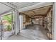 Spacious garage with open door, built in shelving, and workbenches at 7760 Magnolia St, Commerce City, CO 80022