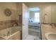 Bathroom with a soaking tub, a sink with a view into a bedroom, providing a tranquil and relaxing experience at 11932 W Long Cir # 202, Littleton, CO 80127