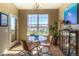 Bright dining area with a glass table, chairs, a chandelier, a large window, and a potted plant at 11932 W Long Cir # 202, Littleton, CO 80127
