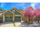 Inviting exterior showcasing a charming townhome with attached garage and a lovely blooming tree in the front yard at 11932 W Long Cir # 202, Littleton, CO 80127