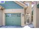 A close-up view of a well-maintained home exterior featuring a single-car garage and front door at 11932 W Long Cir # 202, Littleton, CO 80127
