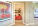 Bright hallway leading to bonus storage room, complemented by an abstract painting and neutral decor at 11932 W Long Cir # 202, Littleton, CO 80127