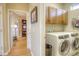Hallway view to a bedroom and laundry room, showing light-colored walls and wood-look flooring at 11932 W Long Cir # 202, Littleton, CO 80127