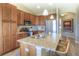 Well-lit kitchen features wood cabinets, granite countertops, stainless steel appliances, and an island with bar stool seating at 11932 W Long Cir # 202, Littleton, CO 80127