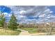 A tranquil park with a winding sidewalk provides neighborhood residents a common area to enjoy at 11932 W Long Cir # 202, Littleton, CO 80127