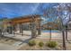 Community pool area featuring a pergola and stone pillars, offering a relaxing outdoor space at 11932 W Long Cir # 202, Littleton, CO 80127