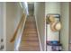 Staircase with wood treads, showing a hat rack and coat hooks, offering an organized entryway at 11932 W Long Cir # 202, Littleton, CO 80127
