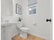 Simple powder room with pedestal sink and wood flooring at 3589 Rucksack Ct, Castle Rock, CO 80108