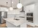 Modern kitchen with white cabinets, island, and stainless steel appliances at 3589 Rucksack Ct, Castle Rock, CO 80108