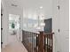 Bright upper hallway with wood railing overlooking the living room at 3589 Rucksack Ct, Castle Rock, CO 80108