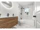 Modern bathroom with a wood vanity, marble tile, and a glass-enclosed shower tub at 3311 Jasmine St, Denver, CO 80207