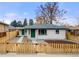 Charming single Gathering home with fenced in yard, green doors and gray roof at 3311 Jasmine St, Denver, CO 80207