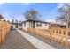 Charming single story house with a walkway, gravel landscaping and wood fence at 3311 Jasmine St, Denver, CO 80207