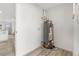 Bright utility room features water heater, white walls and neutral plank flooring at 3311 Jasmine St, Denver, CO 80207