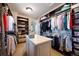 Spacious walk-in closet with custom shelving, hanging rods, and an organization island at 10468 Ladera Dr, Lone Tree, CO 80124