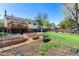 Spacious backyard with a wooden deck, raised garden beds, and lush green grass at 1081 E 119Th Pl, Northglenn, CO 80233