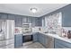 Modern kitchen featuring stainless steel appliances, gray cabinets, and tile backsplash at 1081 E 119Th Pl, Northglenn, CO 80233