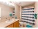 Bathroom with a single sink vanity and a shower-tub combo with blue and white striped curtain at 546 Lost Valley Pt, Castle Rock, CO 80108