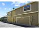Row of attached garages for townhomes with paneled doors and painted tan, green, and beige at 546 Lost Valley Pt, Castle Rock, CO 80108