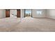 Spacious carpeted basement with natural light, sliding glass doors and wide opening to adjacent room at 12575 Sandstone Dr, Broomfield, CO 80021