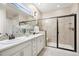 Bathroom features a double sink vanity, walk-in shower with glass enclosure, and a neutral color palette at 12575 Sandstone Dr, Broomfield, CO 80021