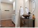 Powder room features a vessel sink, stylish vanity, hardwood floors, and decorative mirror at 12575 Sandstone Dr, Broomfield, CO 80021