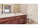 Bathroom with wood cabinets, white countertop and floors, a large mirror, and toilet at 9633 E 5Th Ave # 10304, Denver, CO 80230